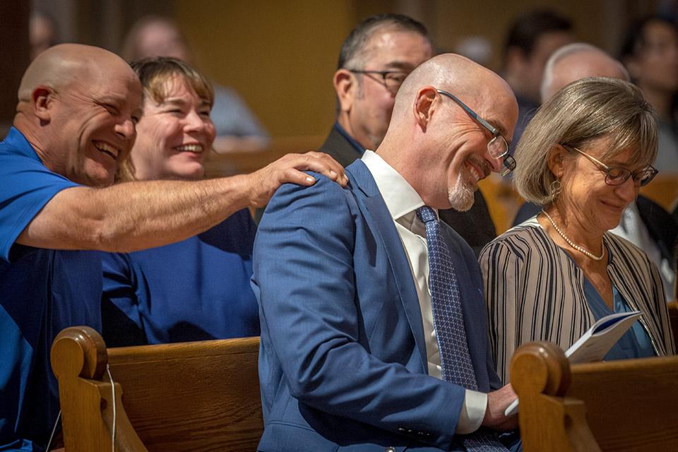 The day before the inauguration, the SLU community gathered in St. Francis Xavier College Church for a Mass of Hope and Community. Here, Feser is congratulated by his brother, Chuck, during the homily.
