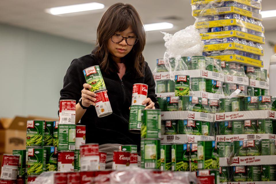Mary Tran of SLU's American Society of Civil Engineers (ASCE) participates in a practice build for Operation Food Search's CANstruction. Photo by Sarah Conroy. 