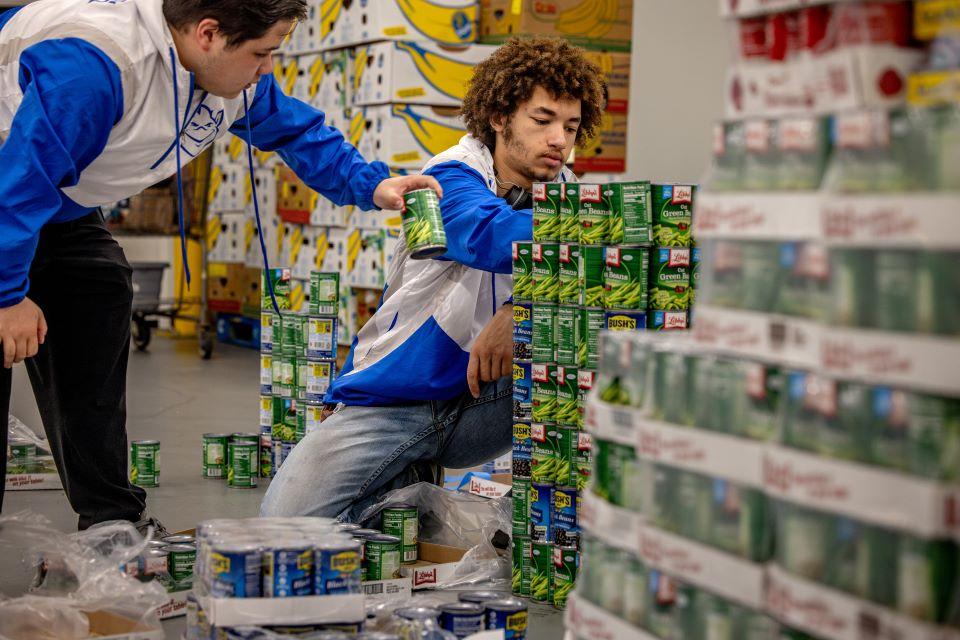 Isaiah Chung and Aureous Ifabiyi-Chope build a practice bridge at Operation Food Search for CANstruction 2026. Photo by Sarah Conroy. 