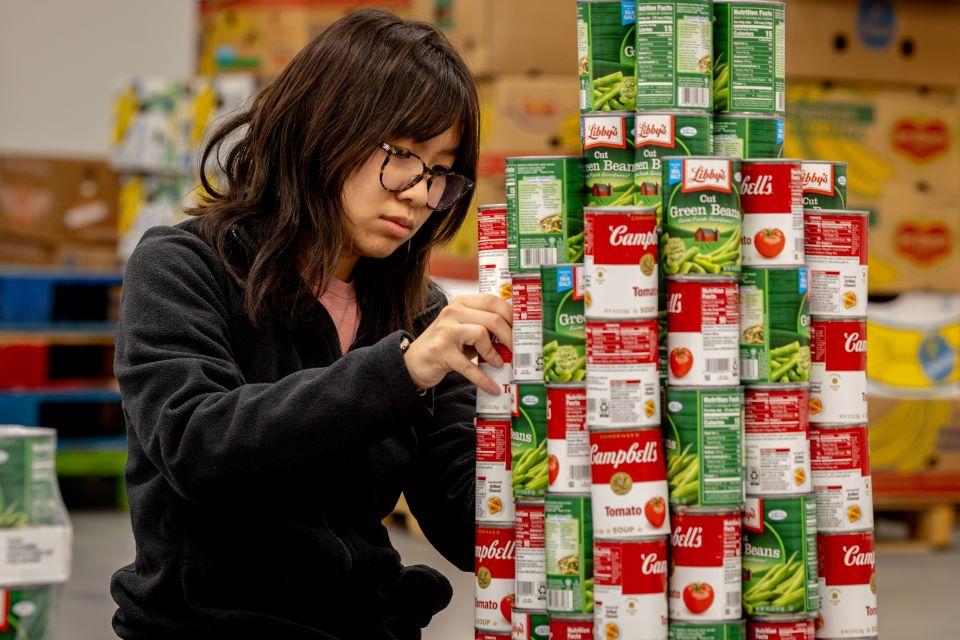 Mary Tran of SLU's American Society of Civil Engineers (ASCE) participates in a practice build for Operation Food Search's CANstruction. Photo by Sarah Conroy. 