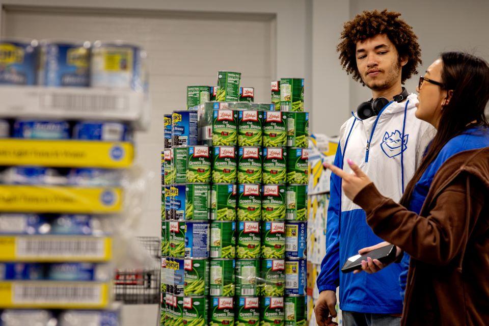 Aureous Ifabiyi-Chope and Kelly Tuong, the two SLU designers for CANstruction, look at a practice bridge at Operation Food Search. Photo by Sarah Conroy. 