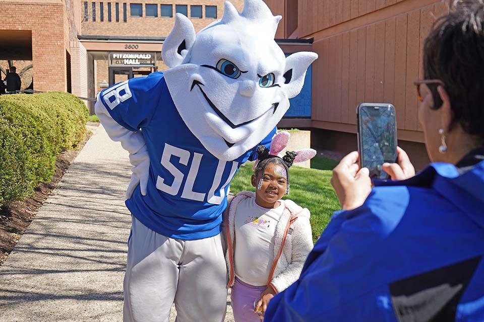 The Billiken poses for a photo with a child at the Easter Egg Hunt on March 28, 2026. Photo by Megan Favignano-Mansouri.