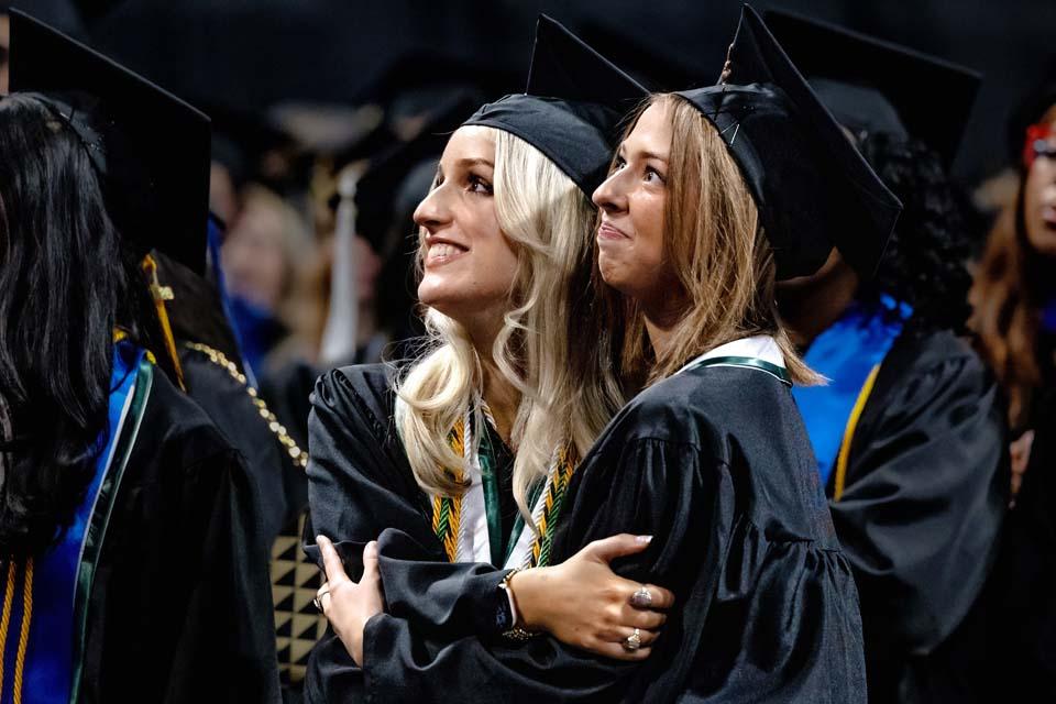 Graduates share a hug during commencement on Saturday, May 16, 2026. Photo by Sarah Conroy.
