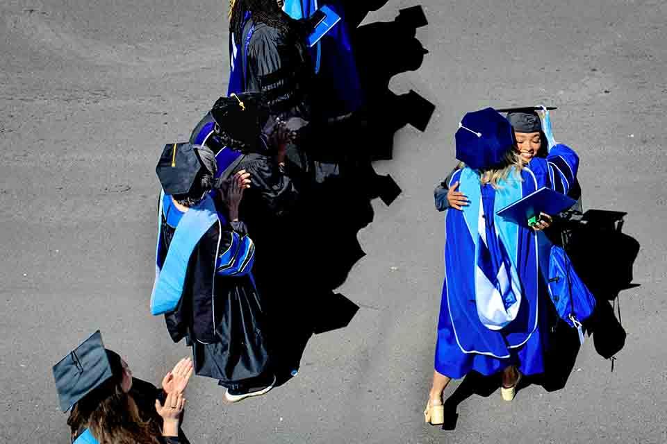 A graduate from the School of Education receives a hug from a faculty member after their precommencement on May 14, 2026. Photo by Sarah Conroy.&nbsp;