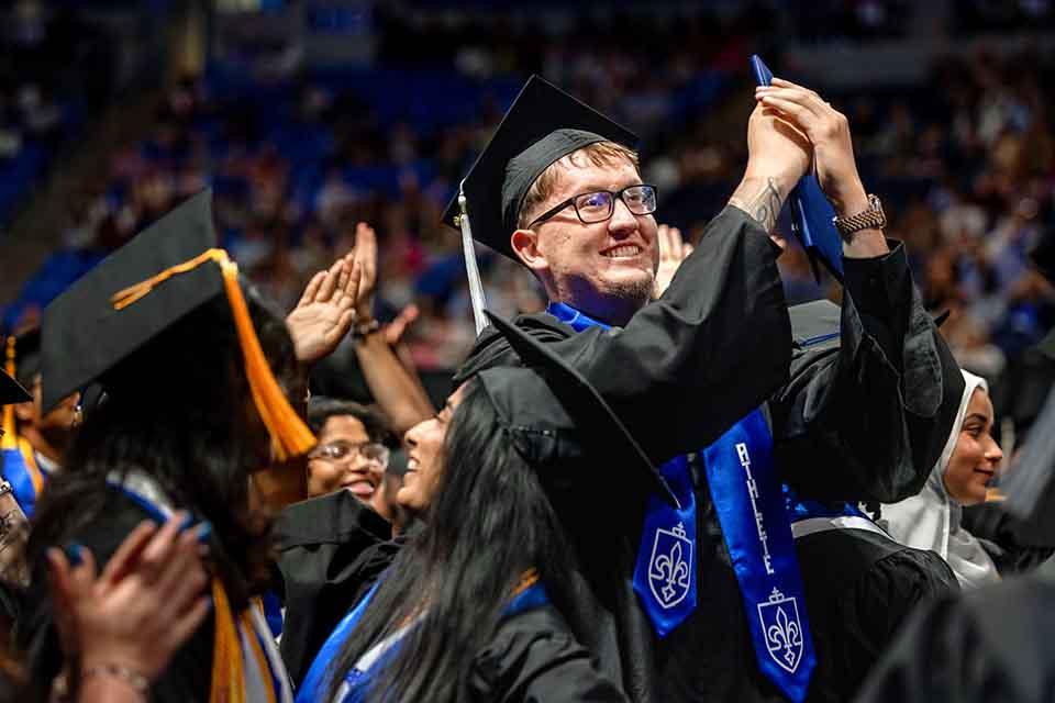 Robbie Avila and other graduates from the College of Arts and Sciences cheer during their precommencement ceremony on May 14, 2026. Photo by Sarah Conroy. 