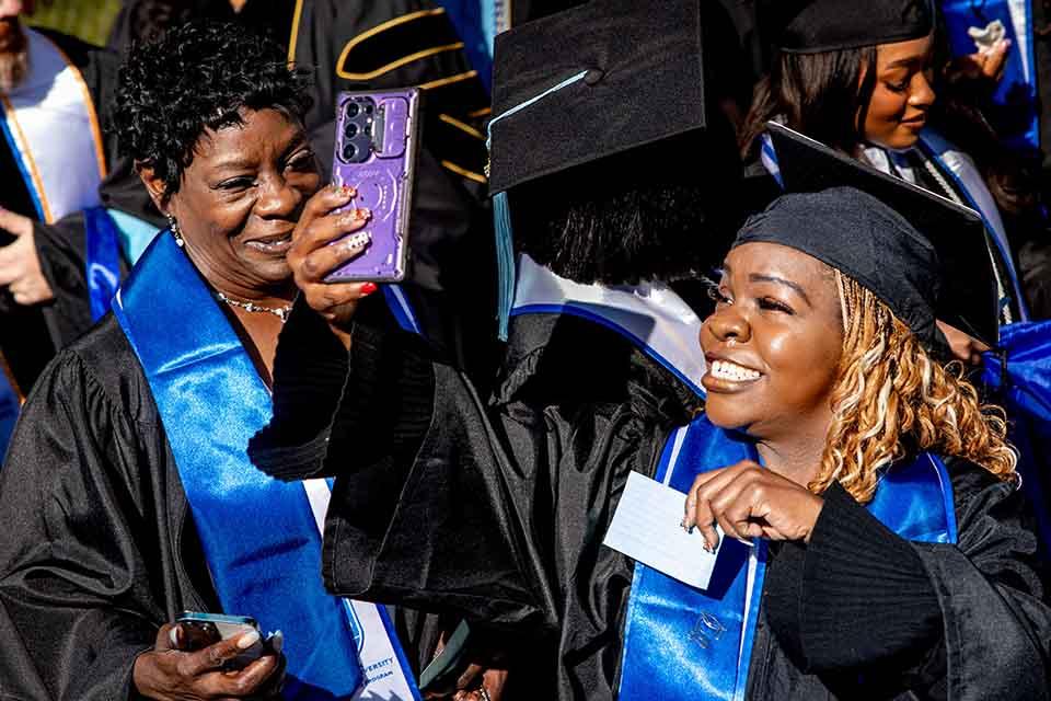 A graduate from the School of Education takes a selfie before their precommencement on May 14, 2026. hoto by Sarah Conroy.&nbsp;
