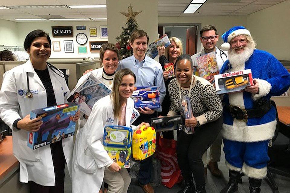 The Hospital Medicine Section contributed many bags of toys towards SLU's Blue Santa program and had fun getting pictures taken with Blue Santa. Pictured (back row, left to right) Nitika Kaswan, M.D., Karra Adams, DNP, Justin Purdy, M.D., Mary Streif, Joe Wheeler, M.D., Blue Santa; (front row, left to right) Jessica Mitchell, PA-C, and Keniesha Thompson, M.D. Photo submitted by Mary Streif
