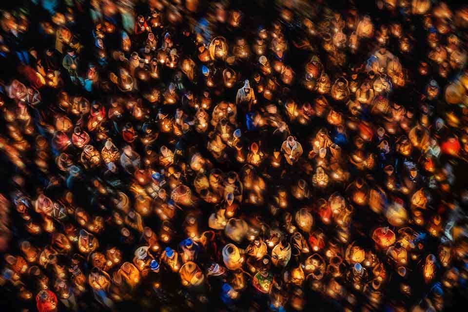 a crowd of people holding candles