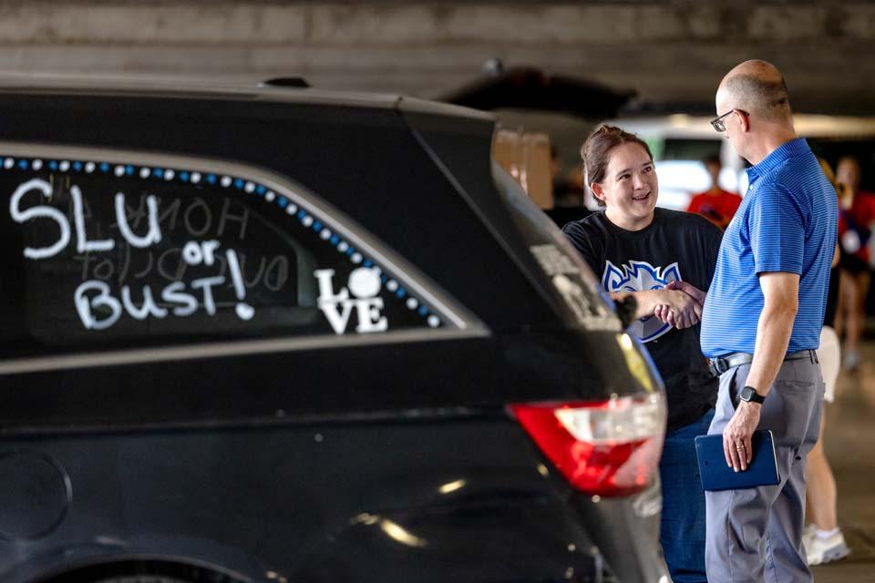 Chris May, director of athletics, greets new SLU families. Photo by Sarah Conroy.
