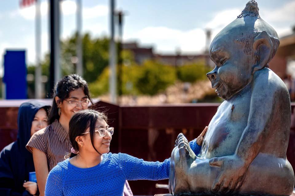 New students rub the Billiken statue’s belly after convocation on Aug. 18, 2026. Photo by Sarah Conroy.