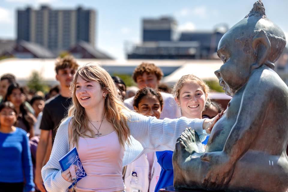 New students rub the Billiken statue’s belly after convocation on Aug. 18, 2026. Photo by Sarah Conroy.
