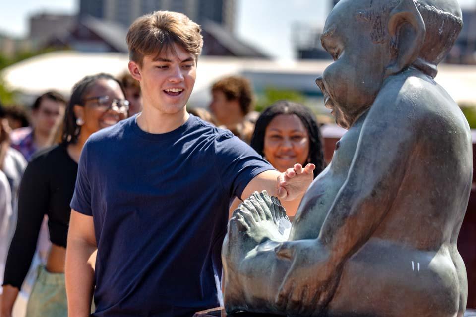 New students rub the Billiken statue’s belly after convocation on Aug. 18, 2026. Photo by Sarah Conroy.