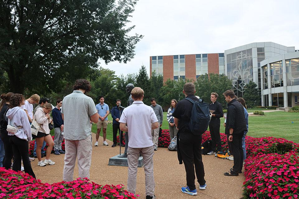 The Camino de SLU pilgrims gather for reflection at the St. Ignatius statue on SLU's quad. Photo by Maggie Rotermund.
