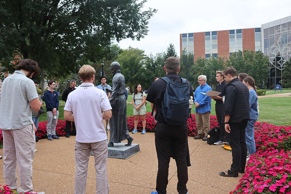 The Camino de SLU pilgrims gather for reflection at the St. Ignatius statue on SLU's quad. Photo by Maggie Rotermund.