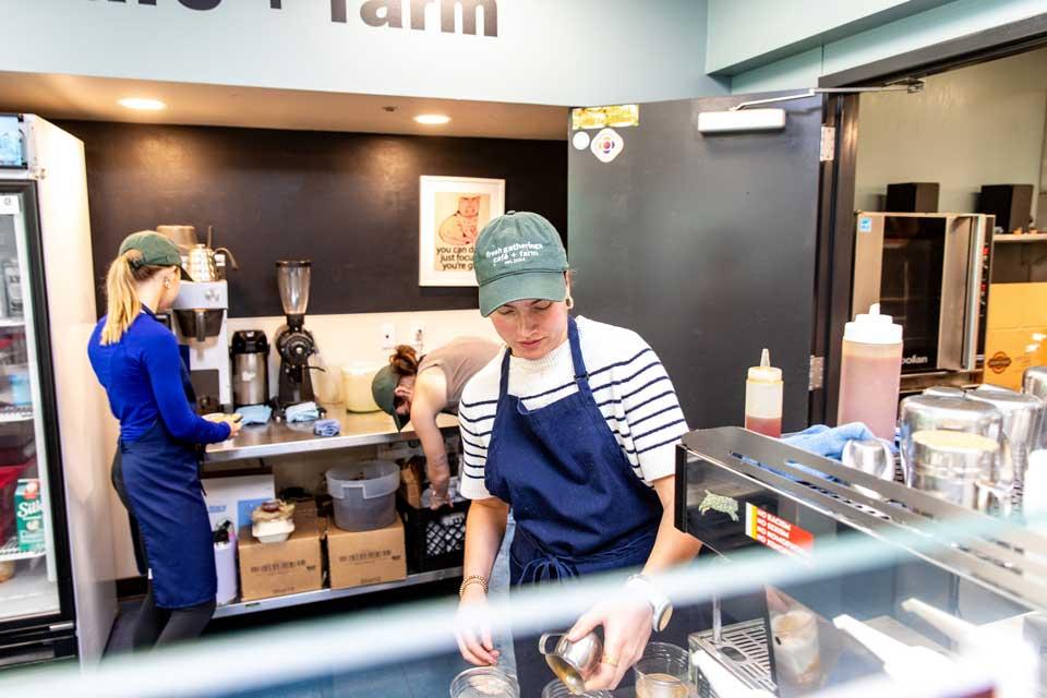 Students at work behind the counter of a cafe.