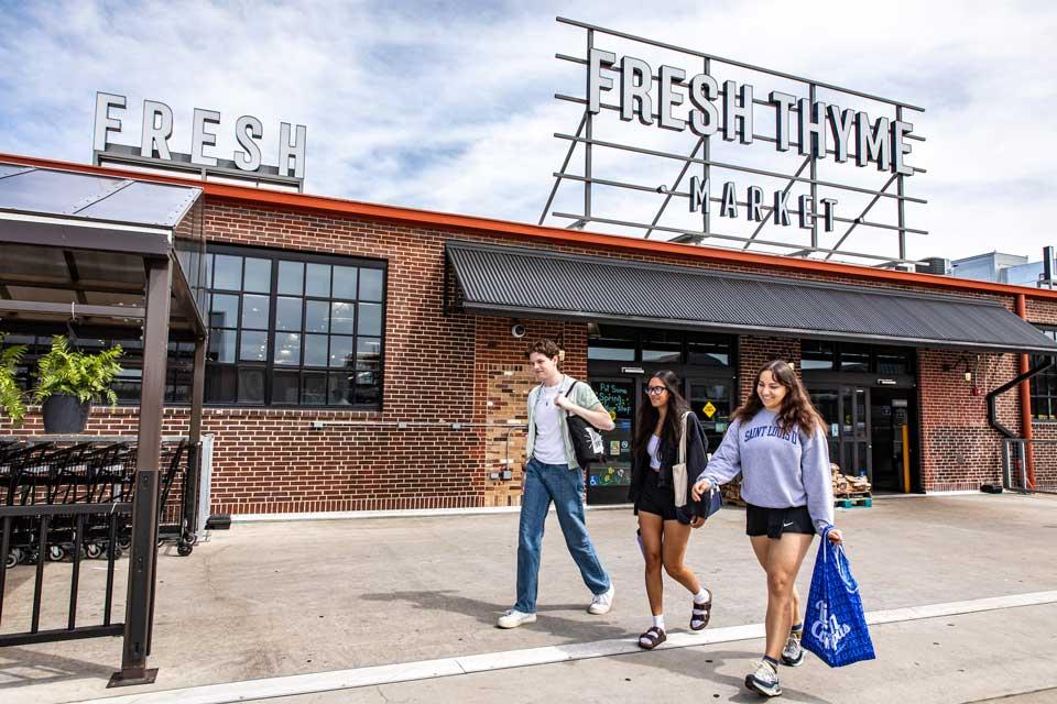 Three students exit a grocery store.