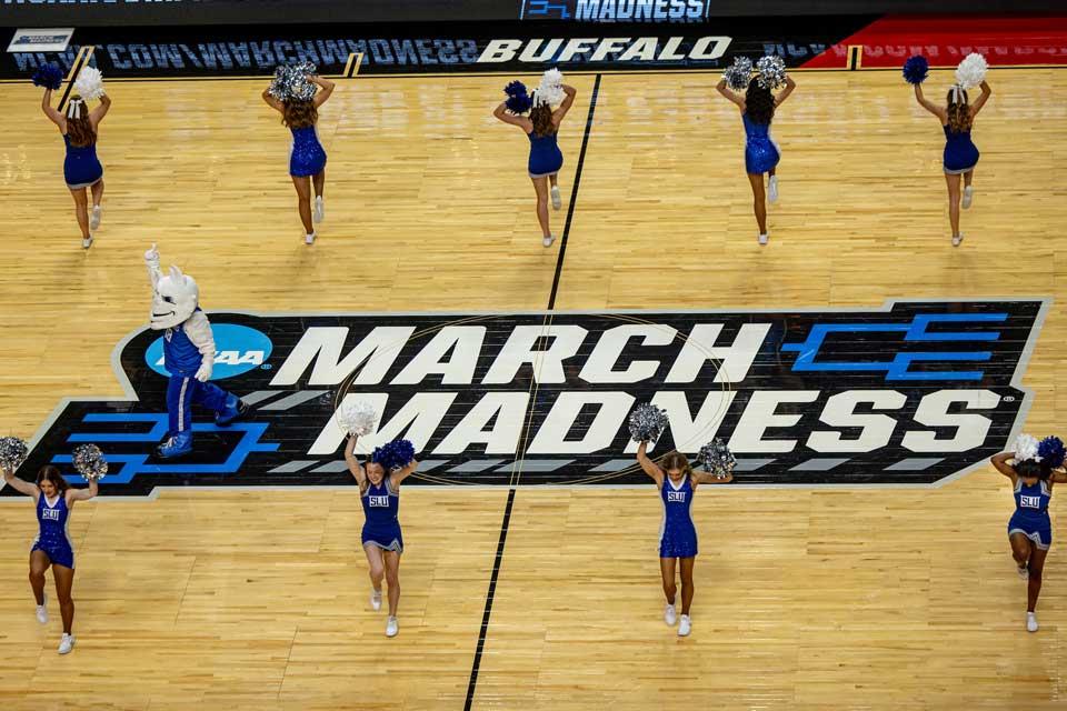 A bird’s eye view of cheerleaders and dancers on the March Madness basketball court.