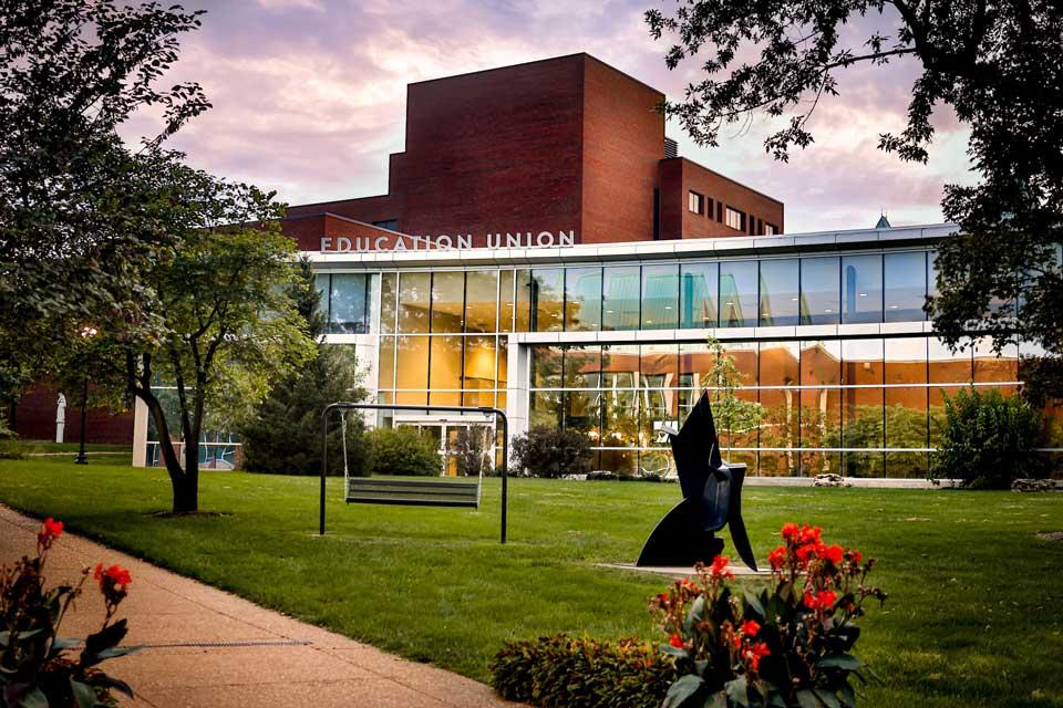 A large window wall of a south campus building at dusk.