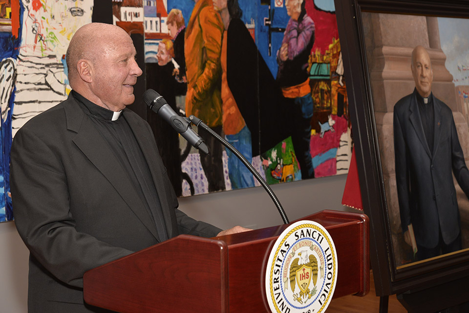 Father Biondi standing at a lectern at his Portrait Unveiling