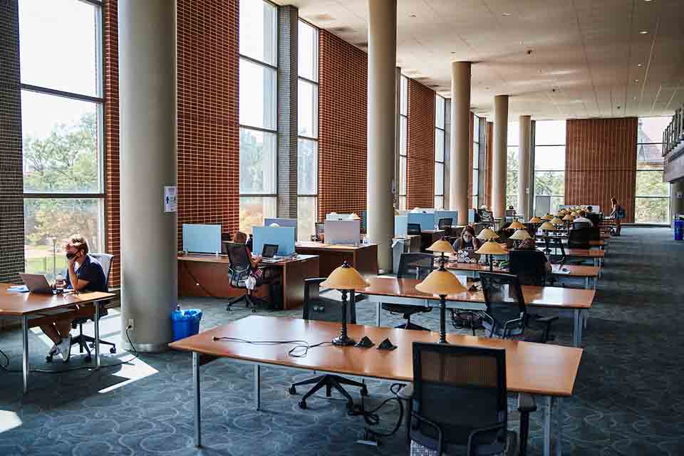 Interior view of Pius Memorial Library showing students sitting at tables studying