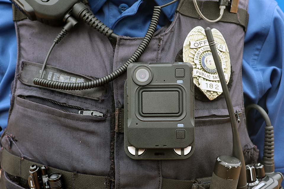Close-up of a DPS officer’s tactical vest with body camera, radio cords, badge, equipment. Close-up of a DPS officer’s tactical vest with body camera, radio cords, badge, equipment.