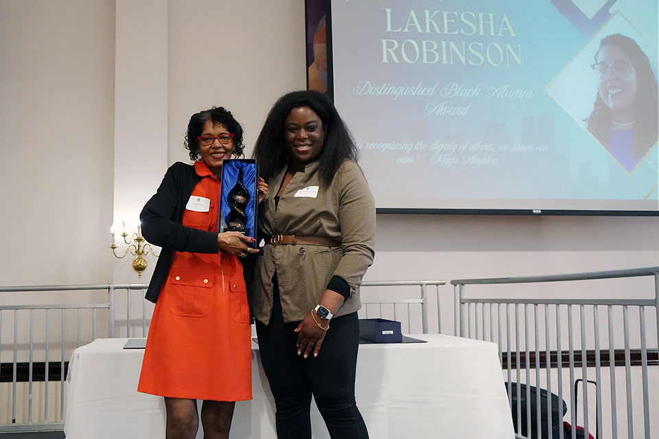 Lakesha Robinson's mother accepts an award on her behalf at an event on campus.