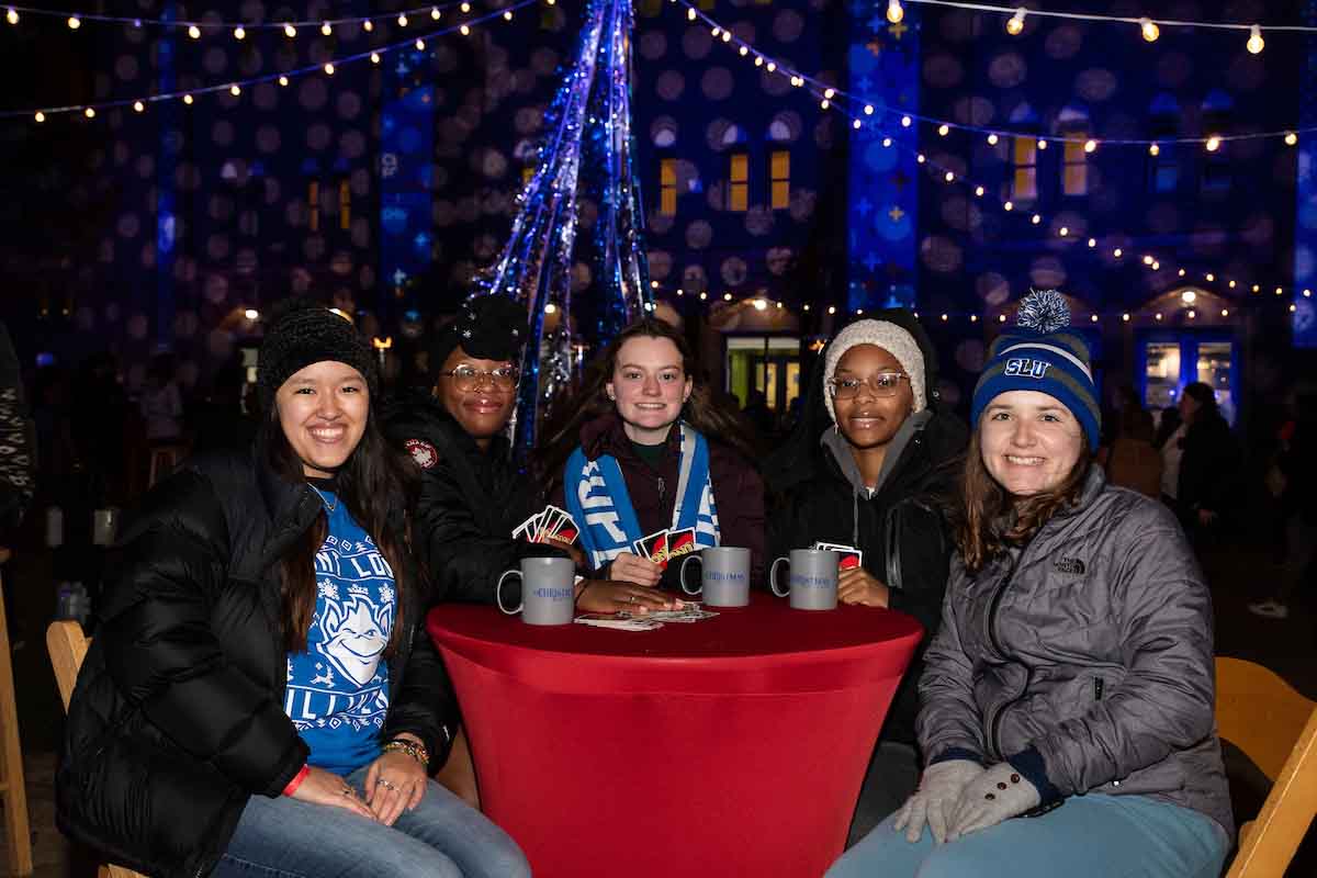 A group of Christmas on the Quad attendees sitting at a table in the Cheer Garden