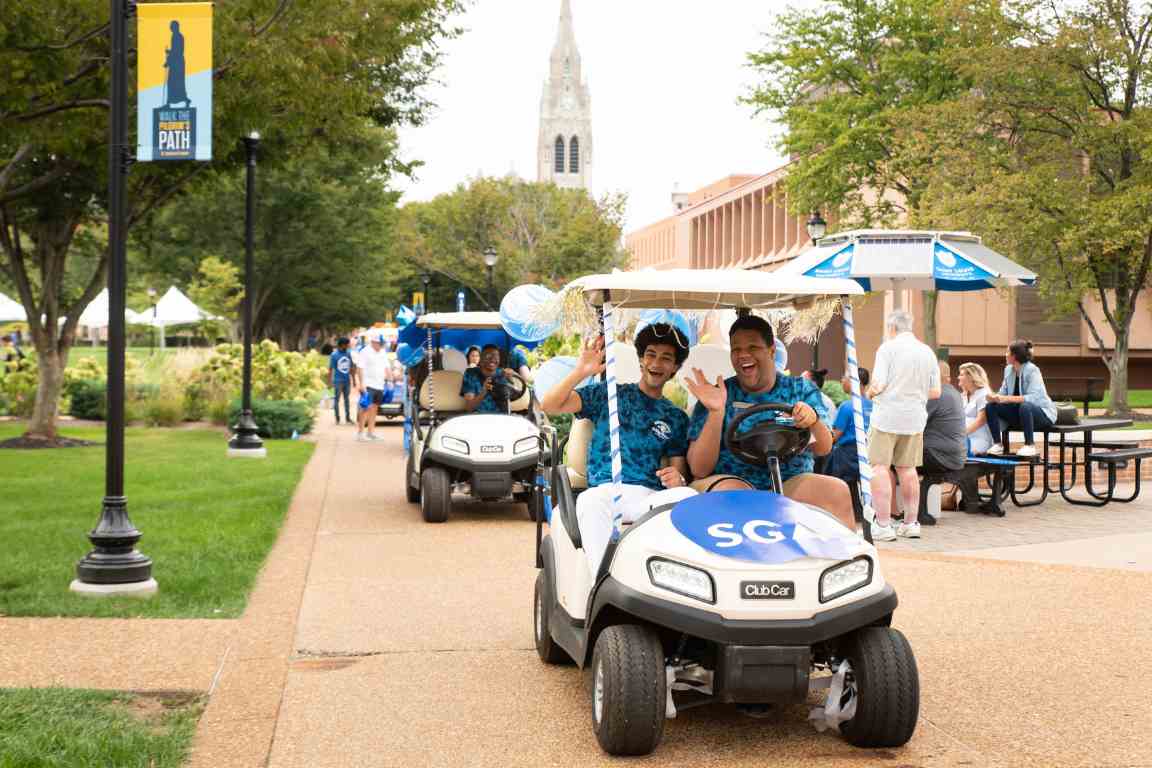 Homecoming Attendees 2021 The Student Government Association golf cart drives across campus with College Church in the background