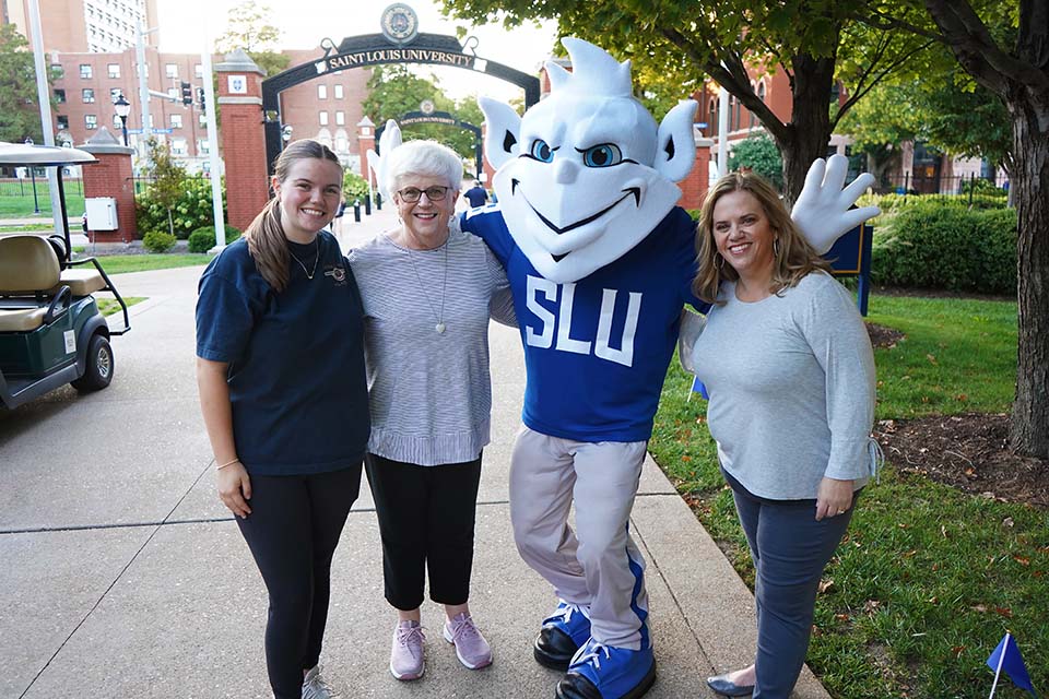 Billiken group photo Three people pose for a photo with the Billiken on campus.