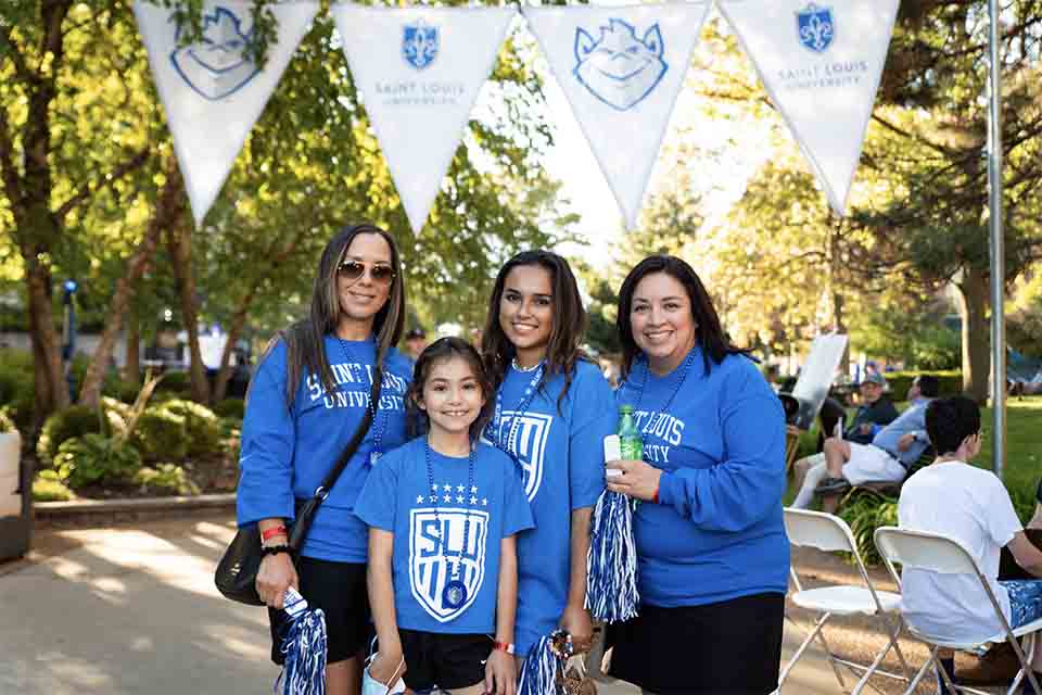 A family in SLU shirts poses on West Pine Mall during homecoming weekend in 2021