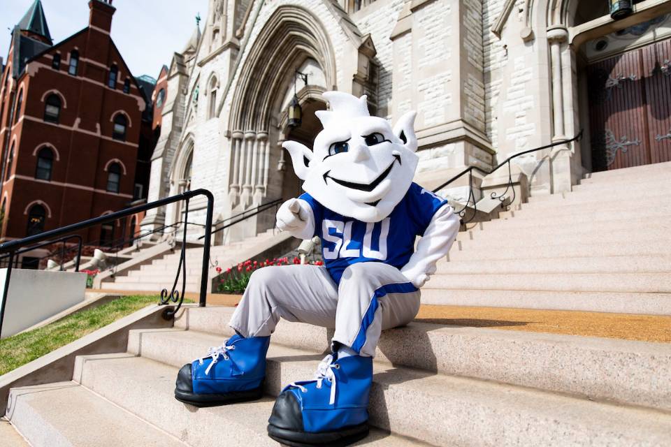 The Billiken sitting on the steps of College Church.