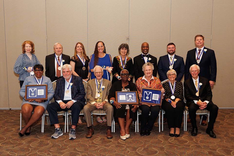 15 of SLU's 2023 Alumni Merit Award winners pose for a group photo.