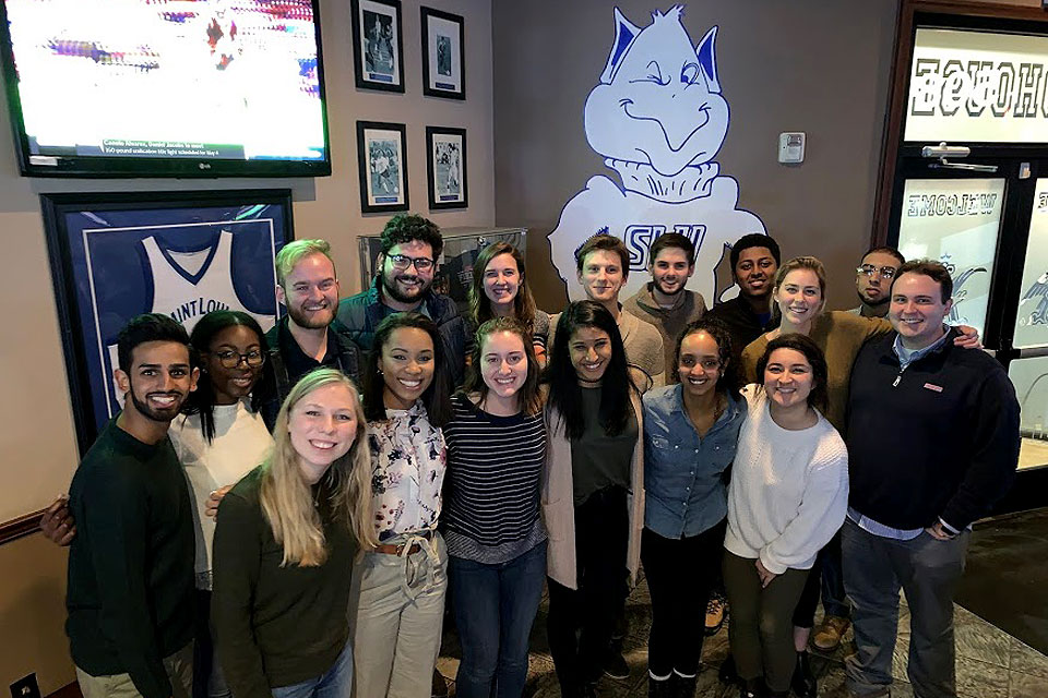 Spirit of the Billiken Award winners 2019 standing in a group in front of a picture of the Billiken mascot