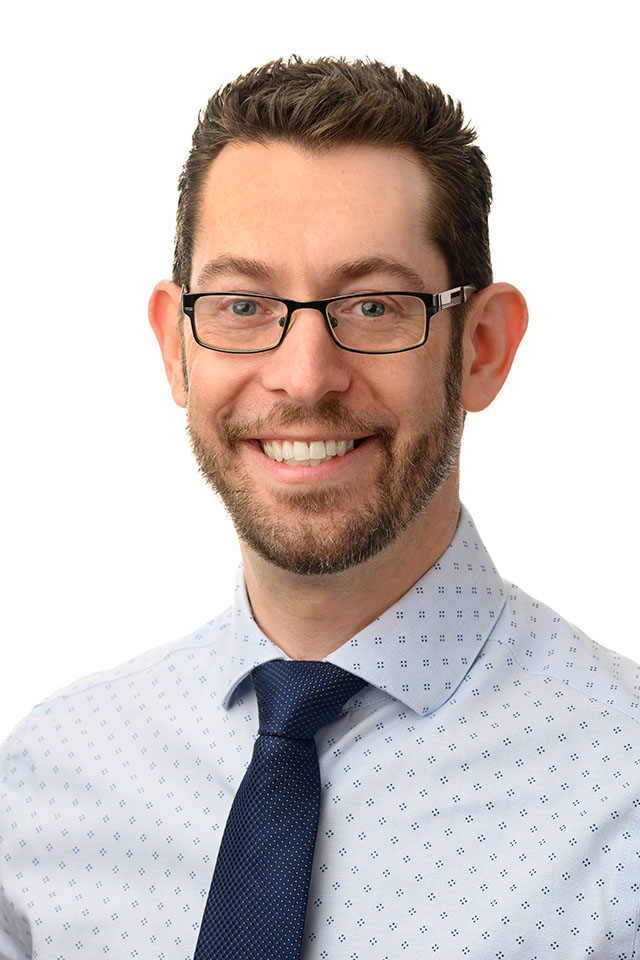 Avi Goldberg Headshot A headshot photo Avi Goldberg wearing glasses in a printed button-up shirt.