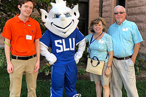 A family poses for a photo with the Billiken.