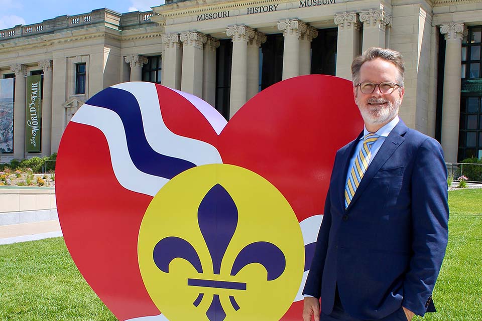 Jody Sowell stands in front of a large heart sign outside of the Missouri History Museum.
