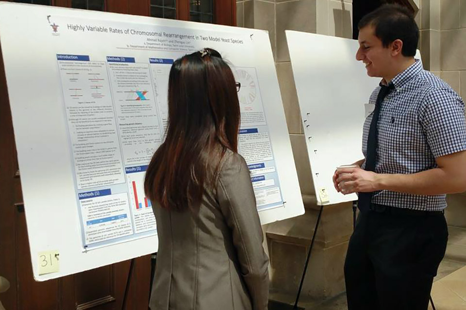 Two students examine a research poster on display.