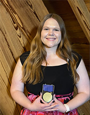 Lauren Morby holds her award medal at a ceremony.