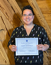 Mary Maxfield holds a certificate.