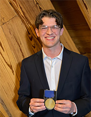 Patrick Bausch holds his medal at the award ceremony.