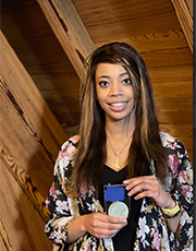 Vanessa Perou holds her medal at a ceremony.
