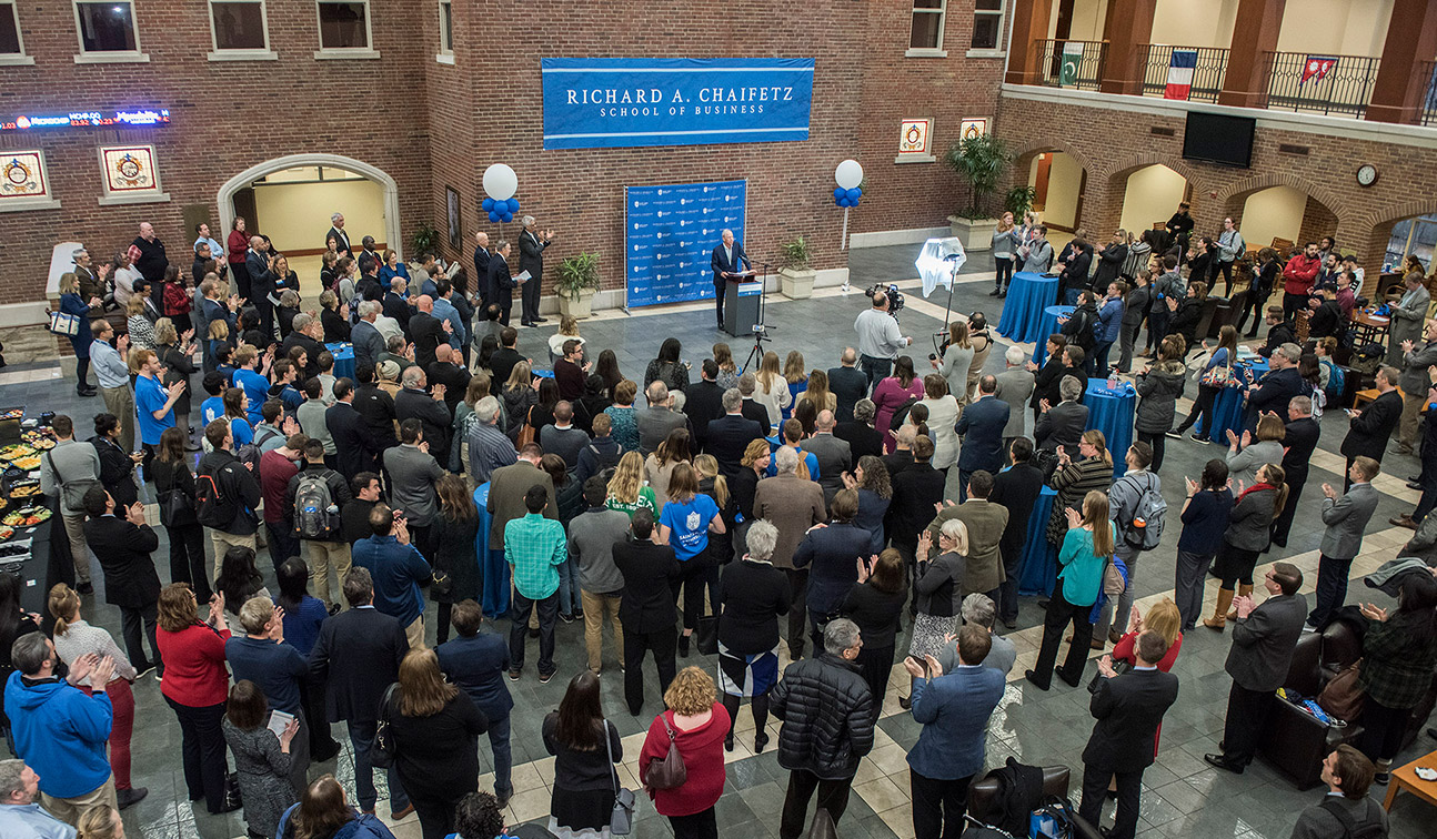 Dr. Richard A. Chaifetz announces a $15 million gift from his family to SLU's business school to a crowd students, alumni and friends from a podium in the atrium of Cook Hall. 