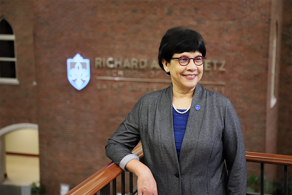 Barnali Gupta, Ph.D., Edward Jones Dean of the Chaifetz School of Business poses on the staircase of Cook Hall.