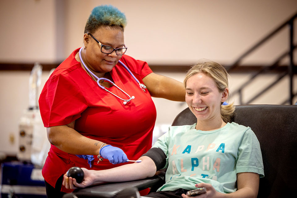 A student squeezes a stress ball while preparing to have her blood drawn during a blood drive hosted by the Center for Social Action.