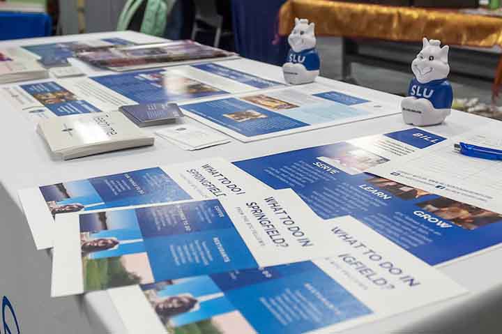 Brochures on a table with Billiken toys