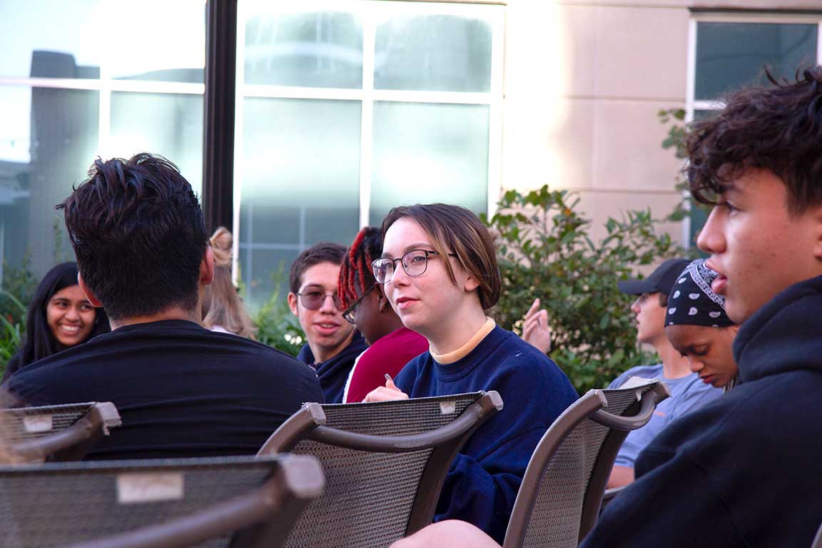 Students sitting in a group on a patio.