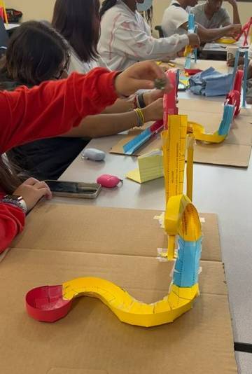 Students place a small ball into a colorful plastic roller coaster.