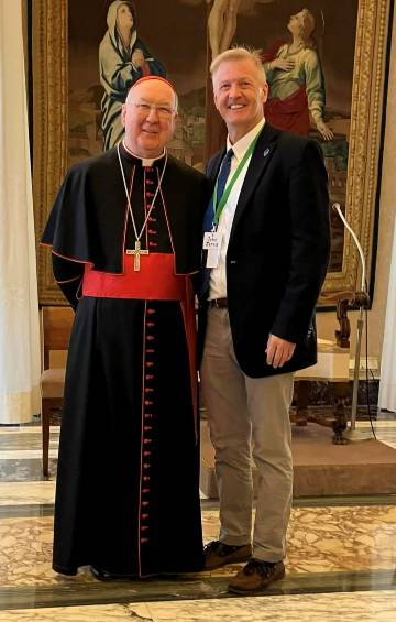 Cardinal Farrell and School of Education Professor John James, Ed.D. smile as they stand together in Rome.