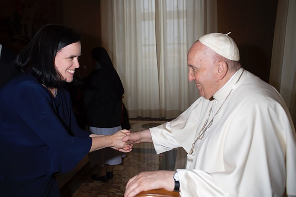 Maureen Wangard shakes hands with Pope Francis. Both are smiling.