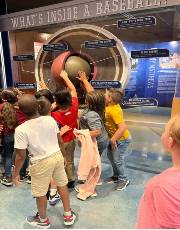 Frontier Schools students Explore an exhibit that says What's Inside of a Baseball.